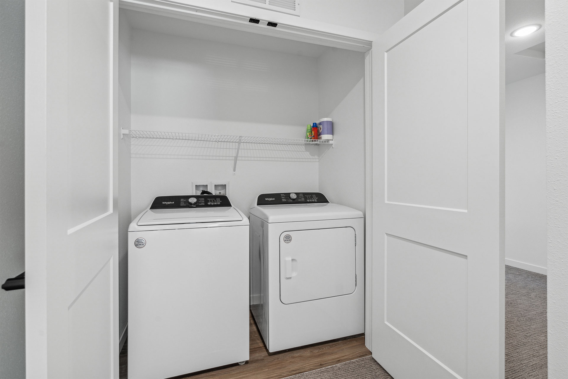 Laundry closet with a washer, dryer, and overhead storage shelf