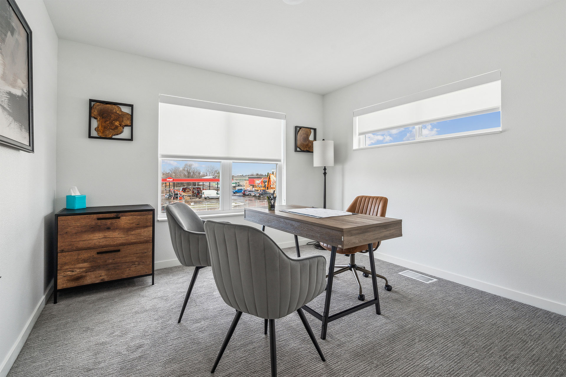 Modern home office with desk, chairs, and large windows